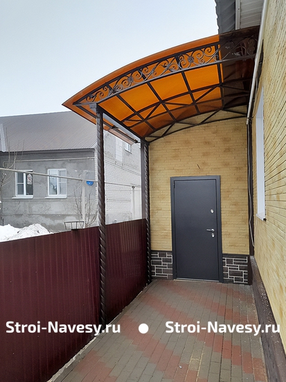 Односкатный навес с поликарбонатом в виде пристройки к дому с декоративной ковкой